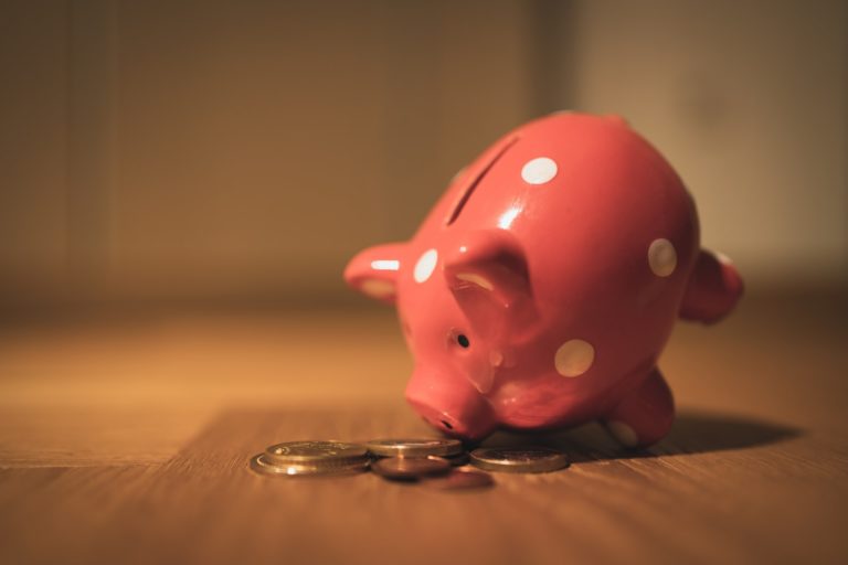 a red piggy bank on a wooden surface