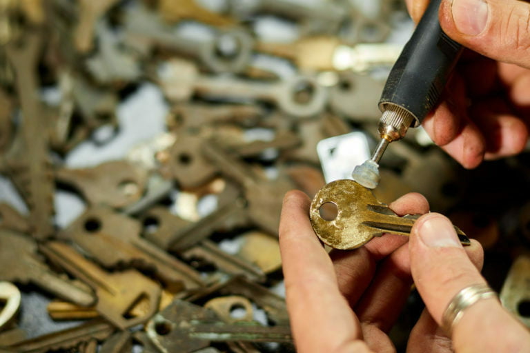 Locksmith in workshop makes new key, use grinding engraving machine